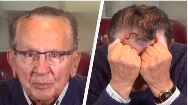 A screenshot from Frank Caprio's video revealing diagnosis. He's wearing a blue sweater with a white collar shirt under it and glasses. Hands on his face.